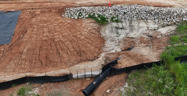 Erosion control as installed — fence, pipe, rip-rap